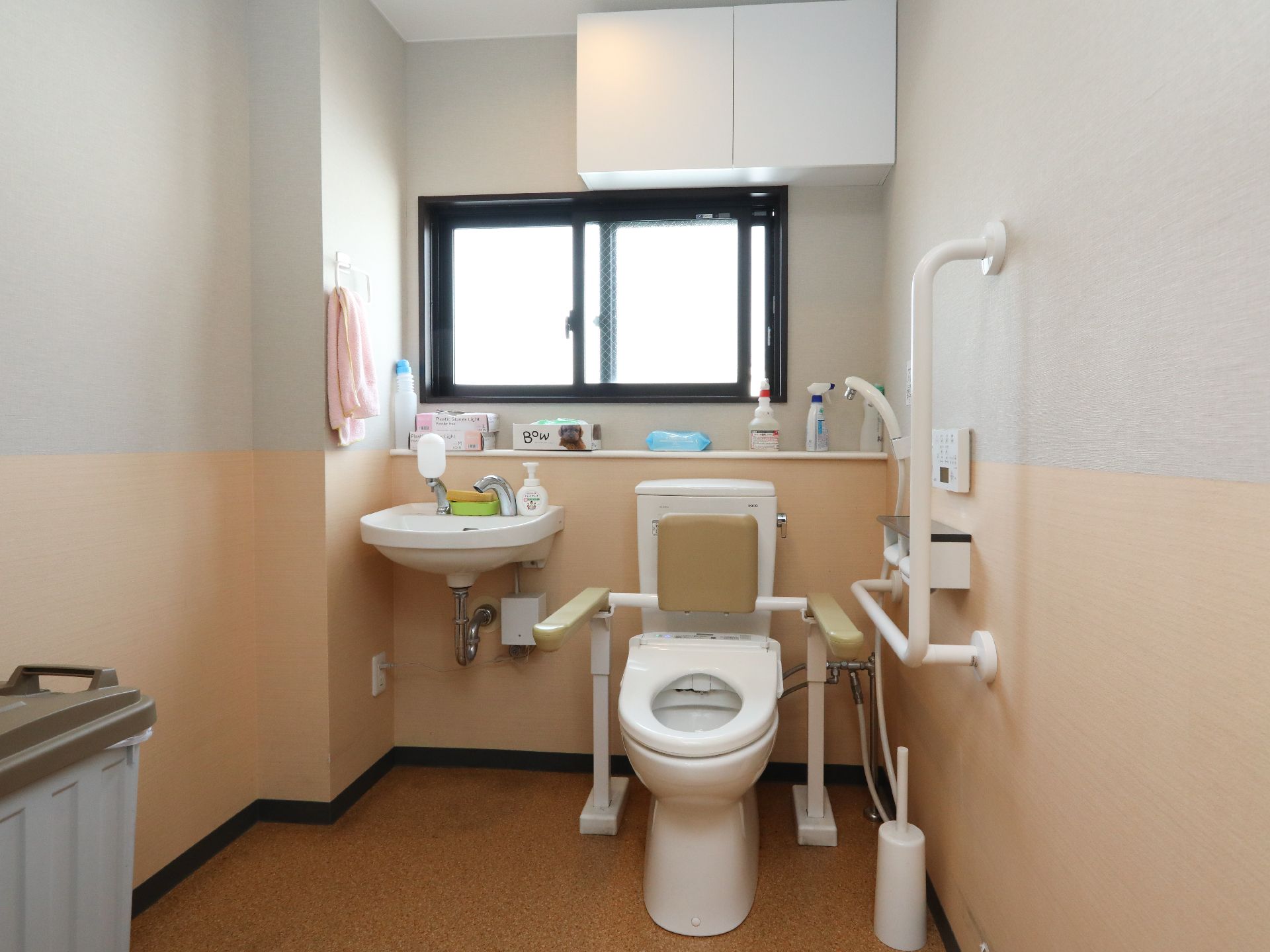 換気窓が設置され、洗面台の横に背もたれパッド付きの温水洗浄便座を完備したトイレ