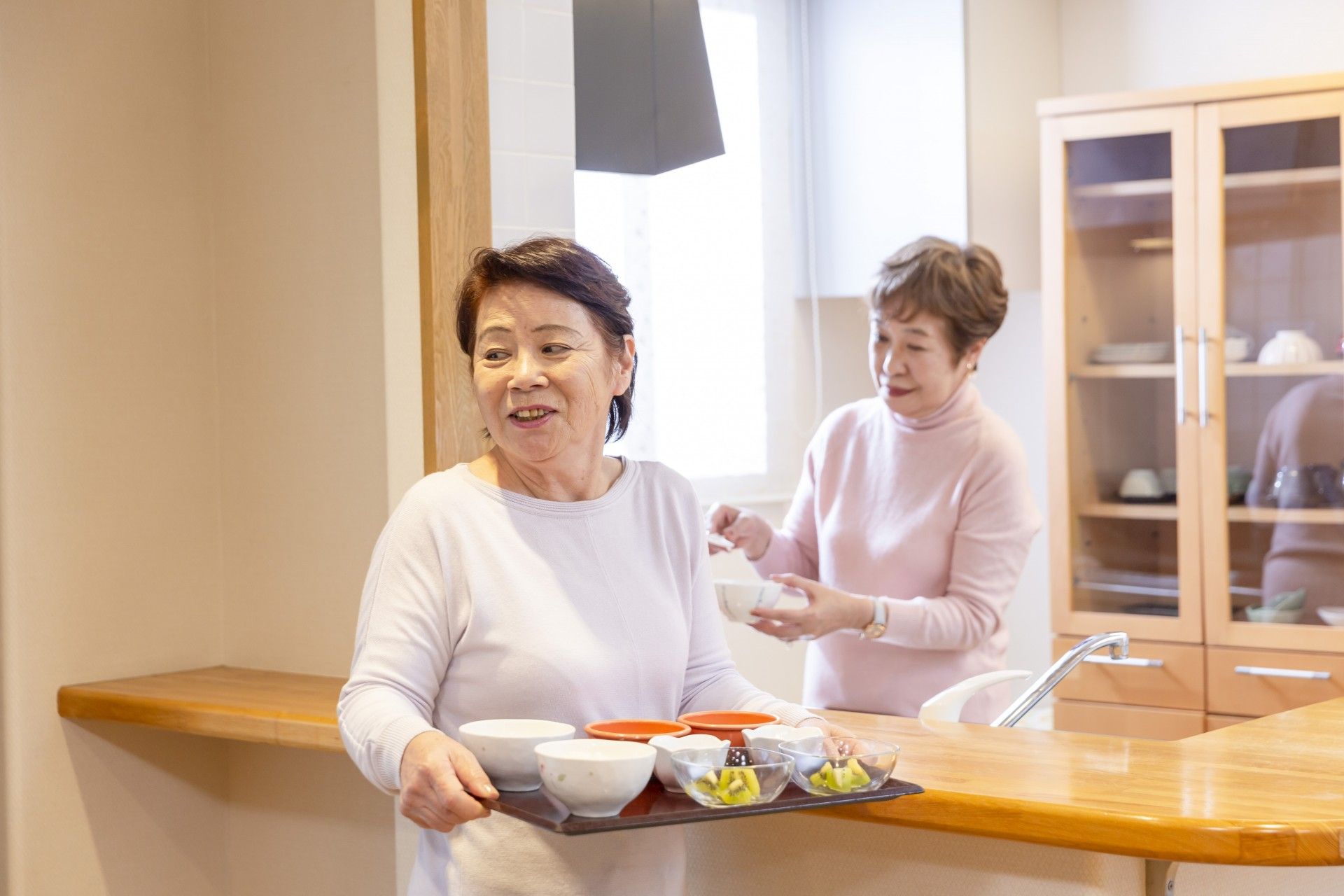 笑顔で食事を運ぶ女性たち