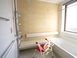 大きな窓が付いた明るい浴室は、壁の一面が木目調になっている。