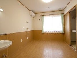 大きな窓が付いた明るい居室にはエアコンや洗面などがある。