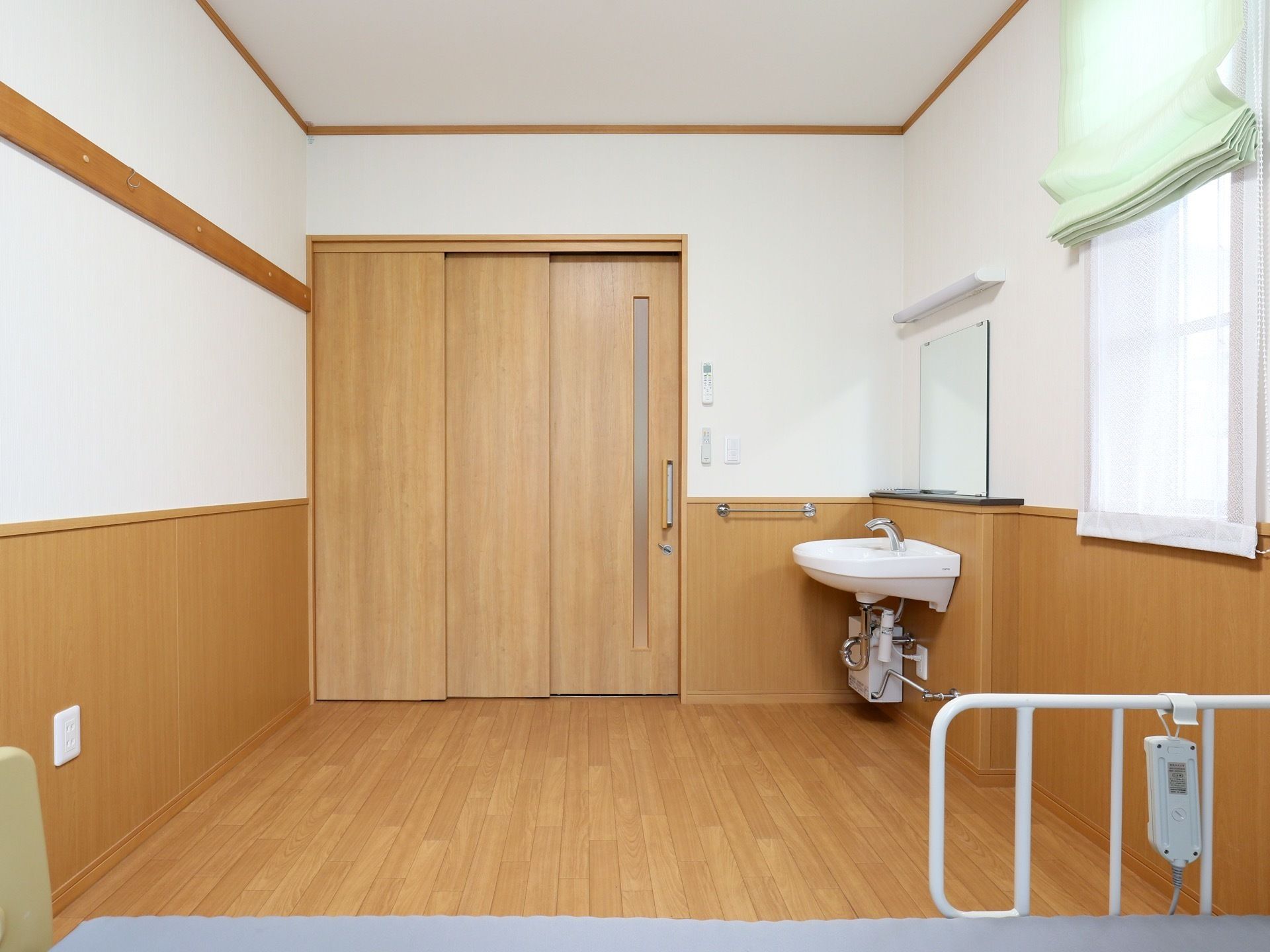 居室は広いフローリングの洋室である。ベッドがあり、洗面台が設置されている。洗面台には鏡がついている。