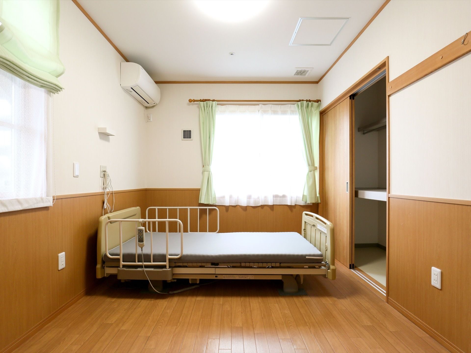 フローリング敷きの洋室にベッドが置かれている。ベッドはリモコンで動かすことができる。収納用に押入れがある。