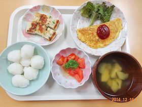ケチャップをのせたオムレツと食べやすく切った野菜や味噌汁のセット
