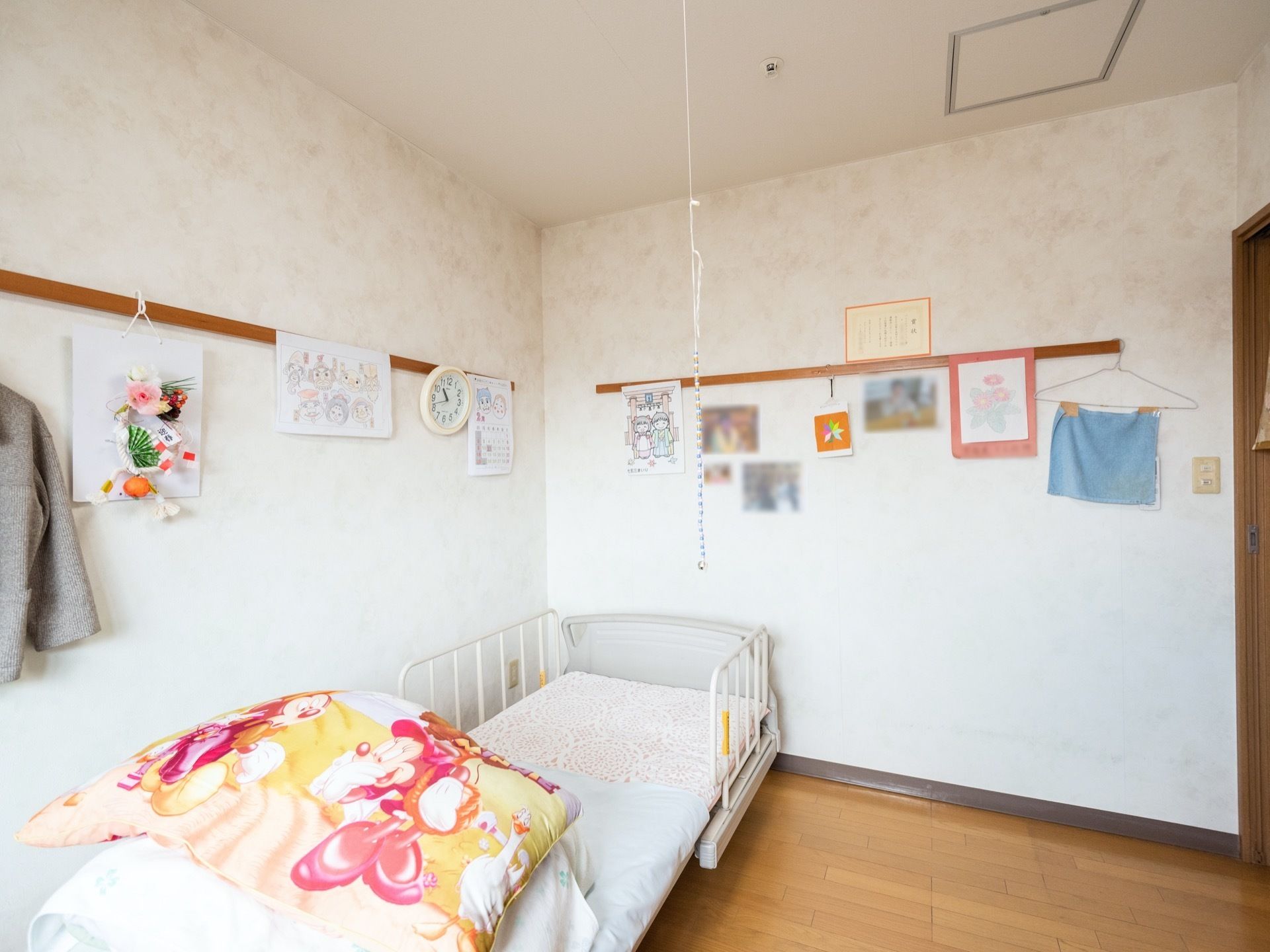 居室には介護用ベッドが設置されている。淡いプリント柄の壁は、入居者様のお好みにレイアウトされている。