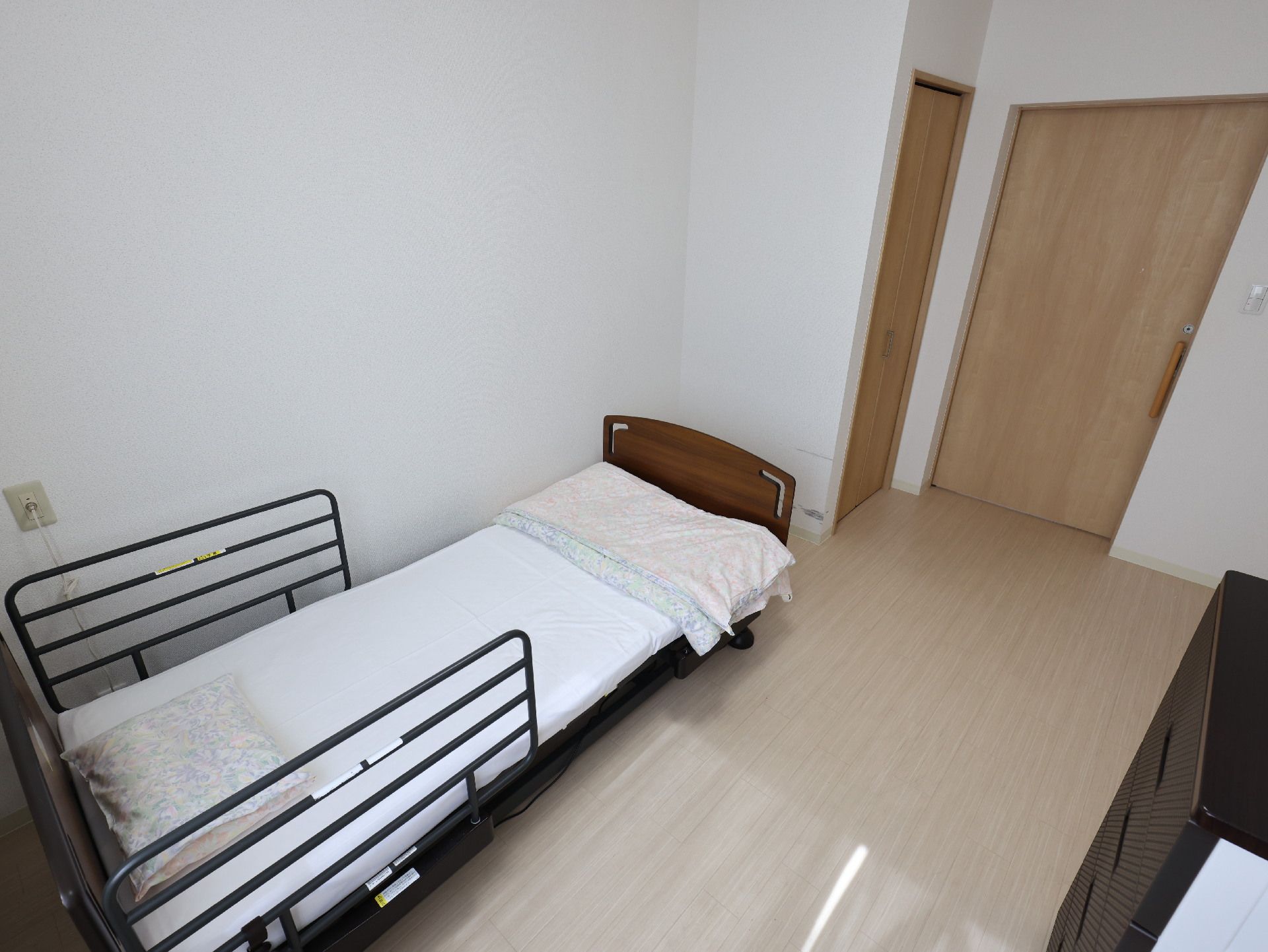 ベッドが置かれた白い壁の部屋