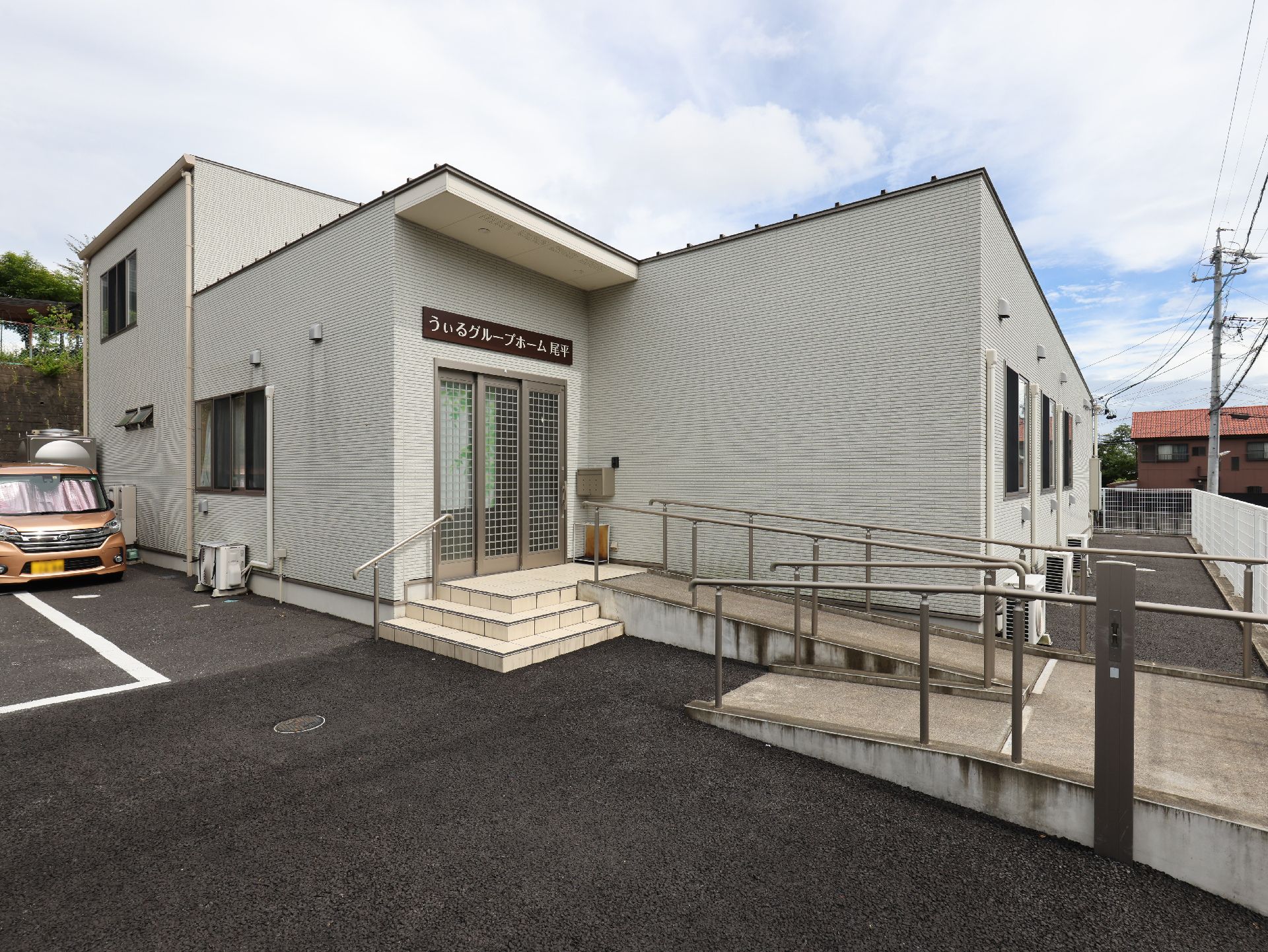 アスファルトに隣接している白い壁の外観
