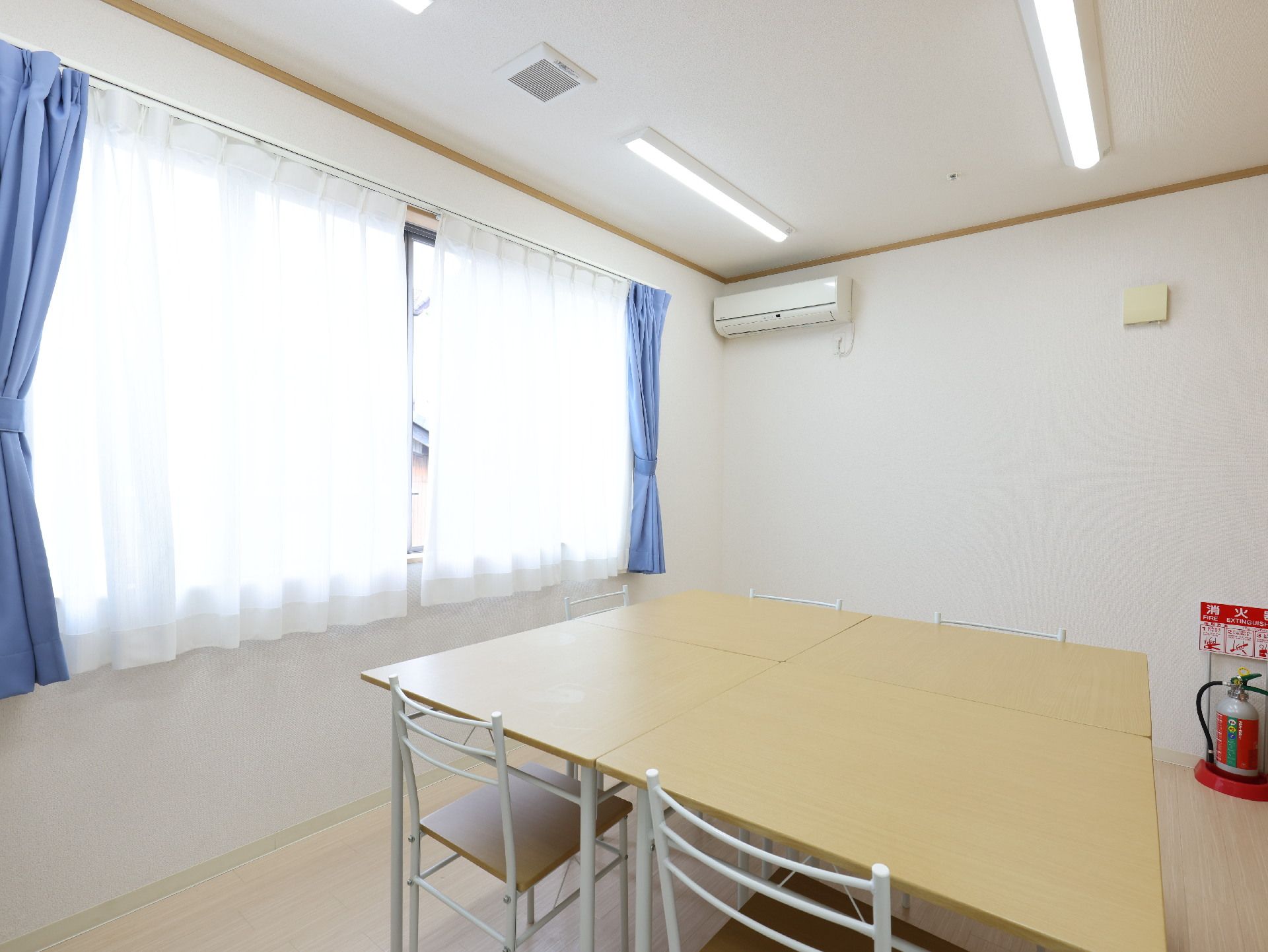木製の机が置かれた白い壁の部屋