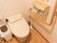 トイレには、便座に近い壁面にＬ字型の手すりが付いている。ペーパーホルダーには上に棚があり、洗浄機能操作ボタンが分かりやすく並んでいる。