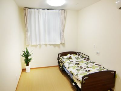 ベッドが右の壁に付けてある小さな部屋の様子。施設内の居室