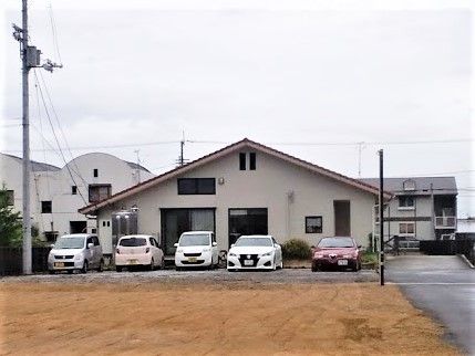 平屋建ての建物は三角屋根で落ち着いた雰囲気。駐車スペースもある。