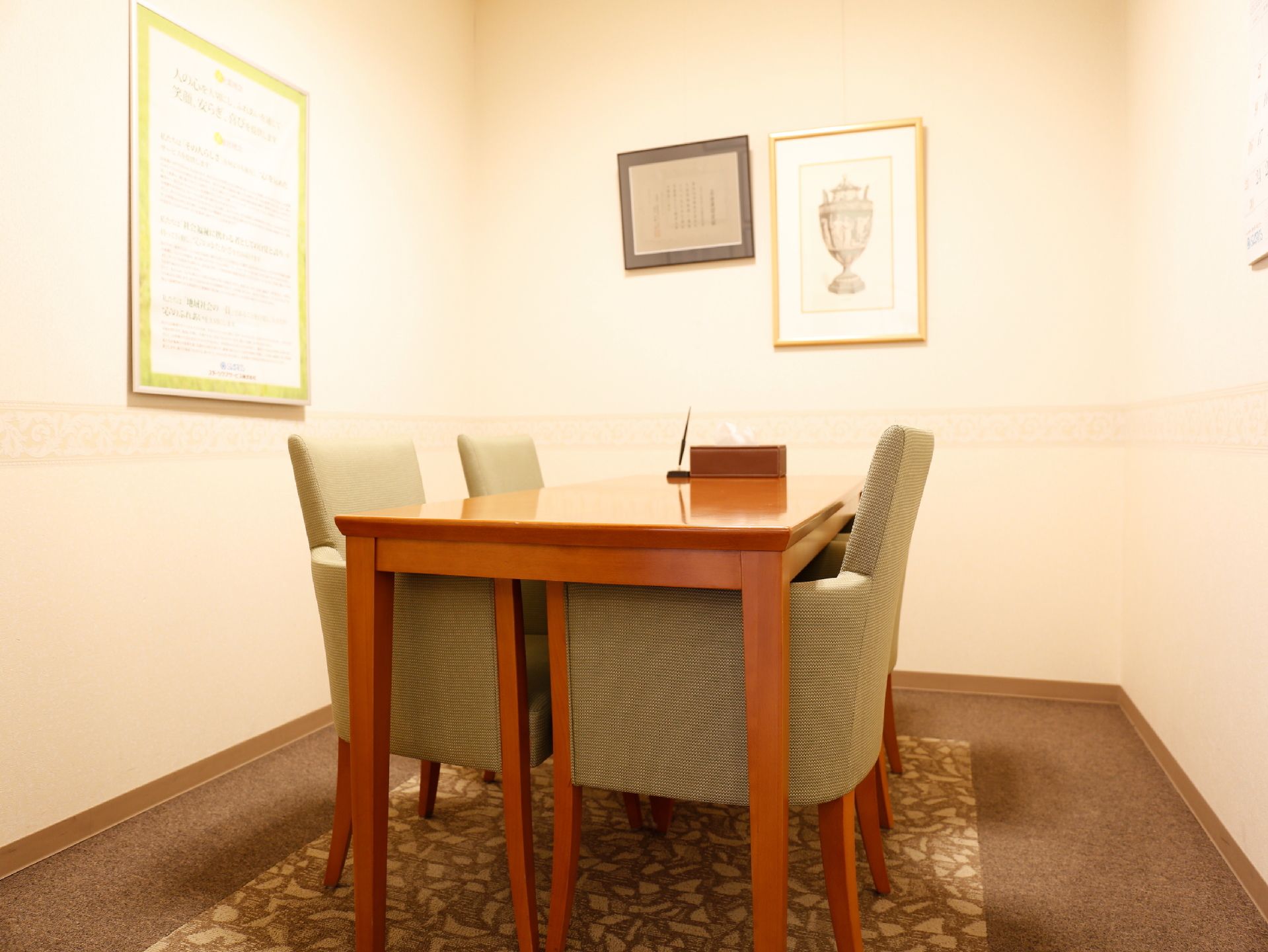 こじんまりとした部屋には、4人掛けの机が置かれている。白い壁には、額に入った賞状や絵がかけられている。