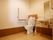 手すりのつけられたタンク付きのトイレと洗面台が設置された室内は、広々としたスペースが確保されている。