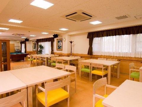 イエローとグリーンの座面の木製チェアが置かれているダイニングルーム
