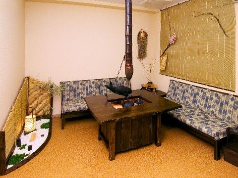 囲炉裏を模したテーブルと和風の布が貼られたソファが置かれている談話コーナー