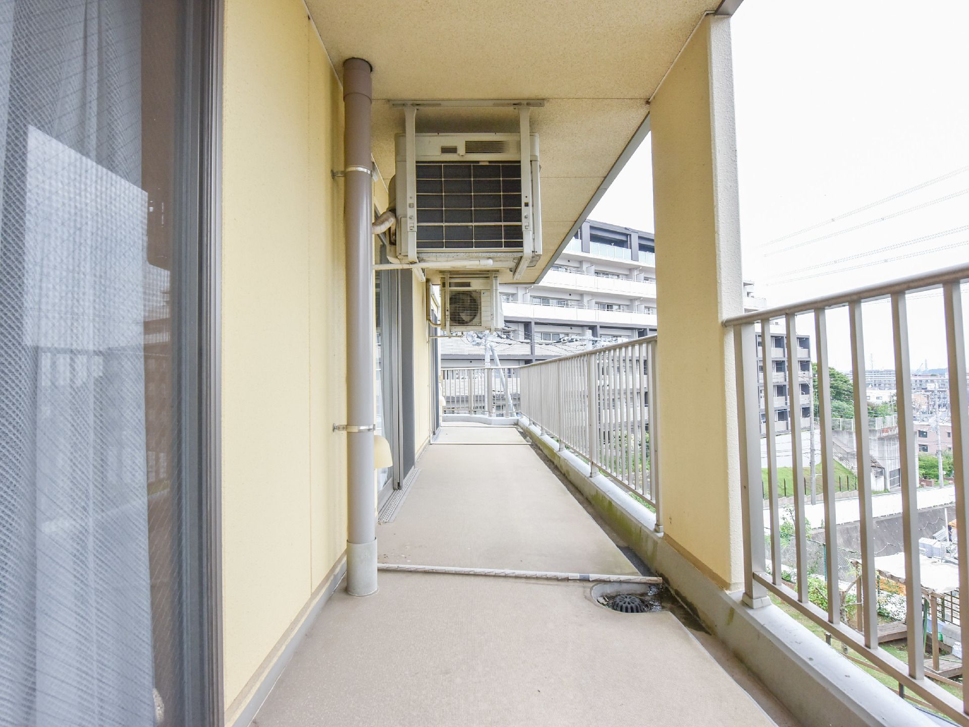 吐き出し窓があり、そこからベランダに出ることができる。室外機が上に設置してある。ストライプフェンスがある。