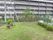 鉄筋コンクリート4階建ての建物である。芝生が敷いてある公園がある。レンガと木で作られたベンチが置いてある。