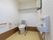 洋式トイレである。手すりが両脇に設置してある。上部に棚がある。ウォッシュレットタイプである。手を洗う場が独立して部屋内に設置してある。