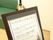 バンケットルームと書いたボードが部屋の前に置いてあり、その部屋の説明が書いてある。背部にソファが見える。