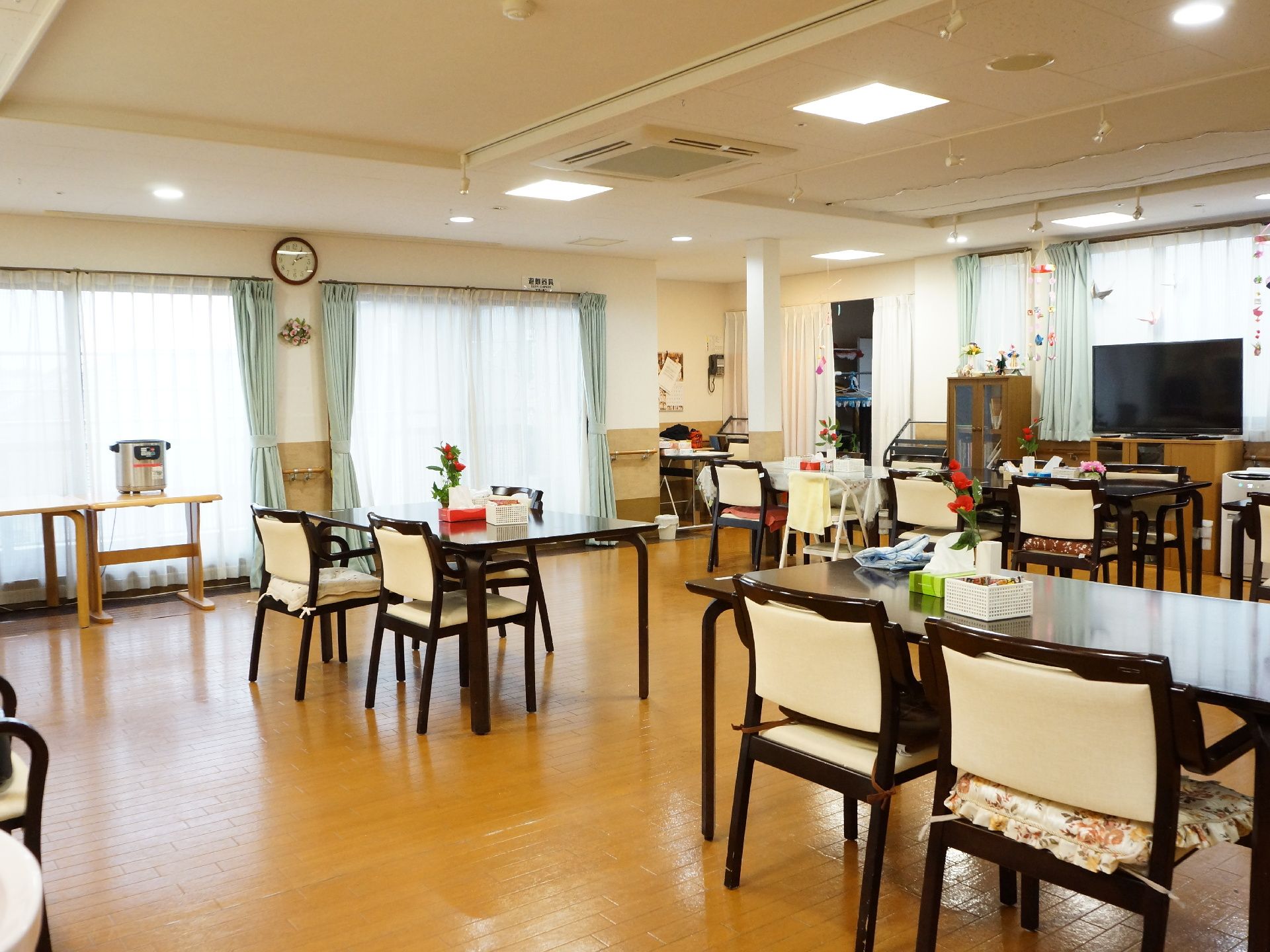 食堂の窓際には長いテーブルがおいてあり、炊飯器が置いてある。キャビネット、TVラック、TVなどがある。