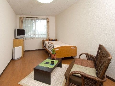 居室には空気清浄機を設置しているので、きれいな空気の中で生活を送れる。室内にはベッドや二人掛けの椅子などの必要な家具や家電を用意している。