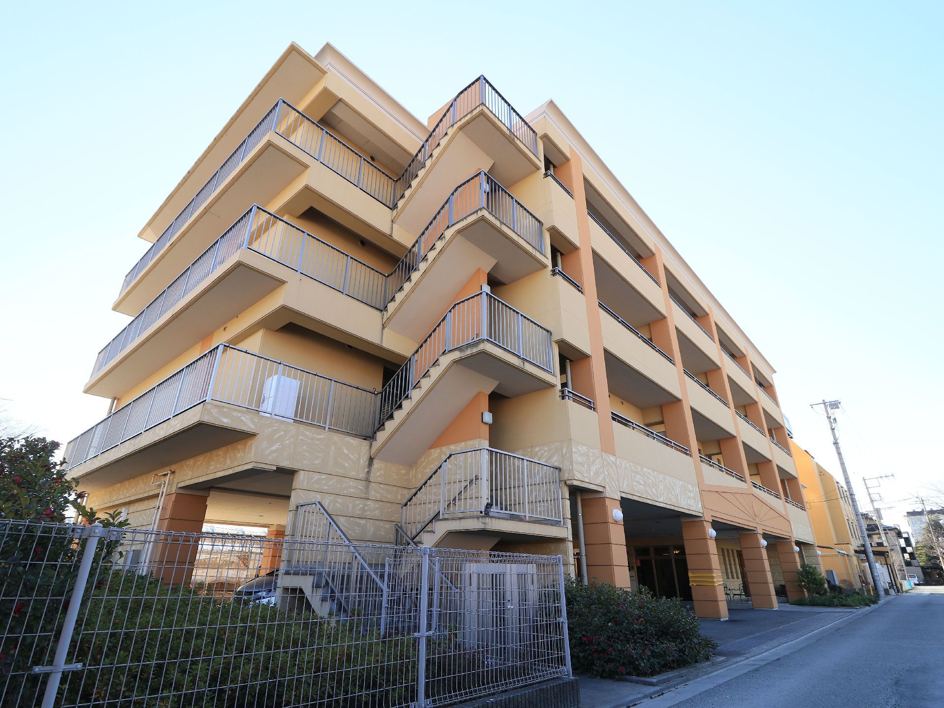５階建てマンションのような外観の施設である。外階段が設置されており、バルコニーが居室に設けられている。