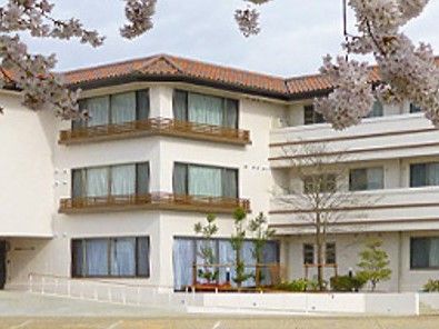 桜に囲まれた建物外観