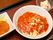 スパゲッティにはトマトソースがかけられ粉チーズがふられている。水玉のお皿に盛りつけられており、色彩も豊かで食欲をそそる。