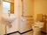 洋式のトイレには手すりや背もたれが備わっている。洗面台が併設されており、ハンドソープが置かれている。室内は白色と淡い茶色を基調としている。