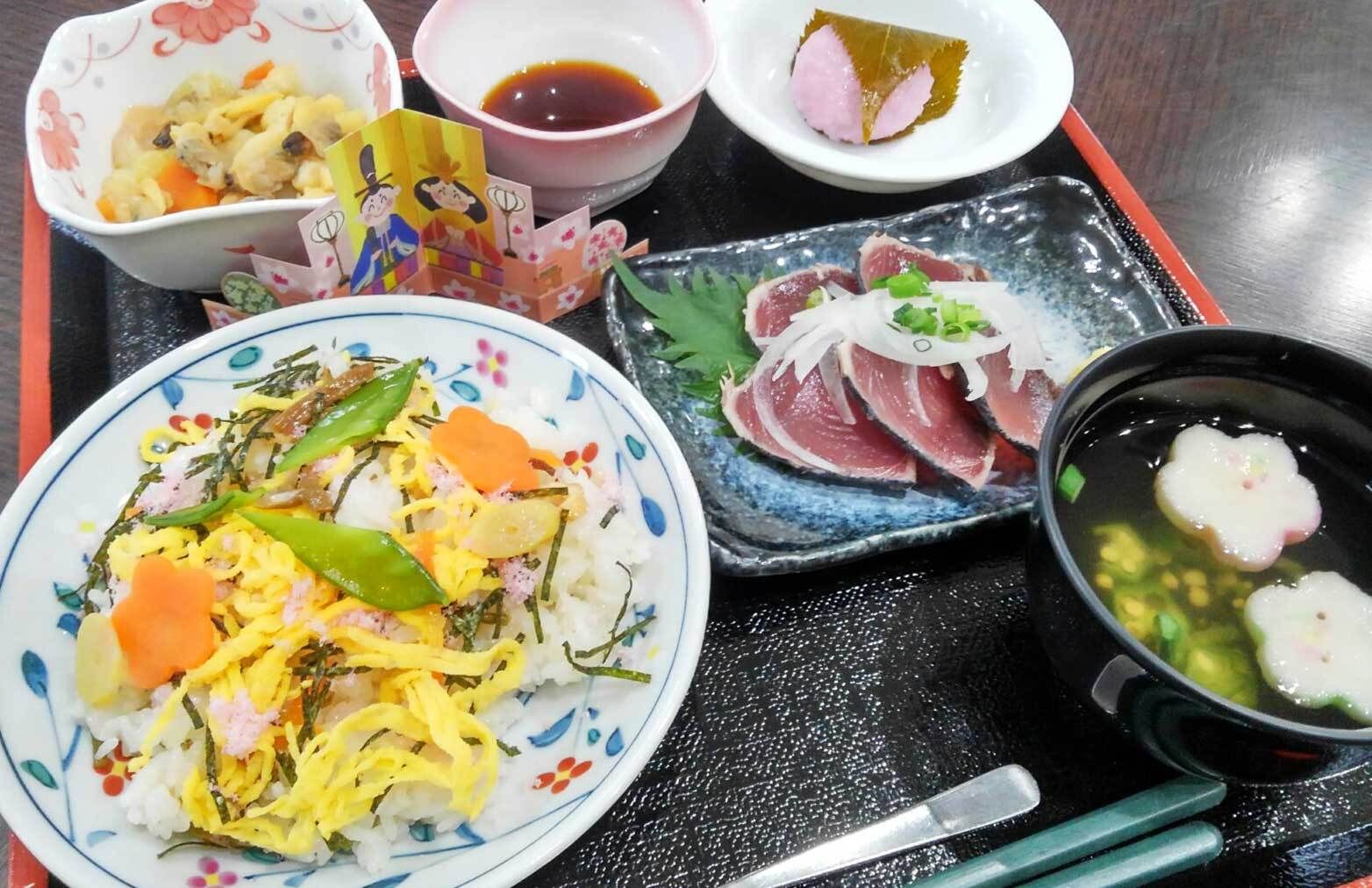 ちらし寿司とかつおのたたき、吸い物と桜餅が付いたひな祭りの特別食