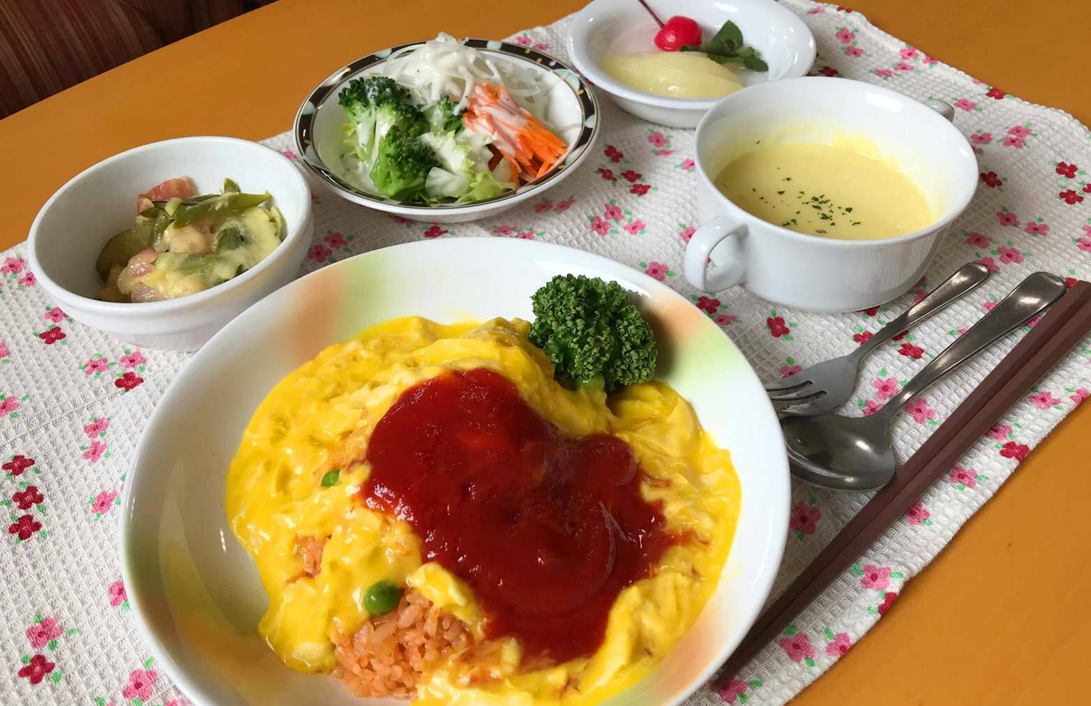 オムライスとコーンポタージュやサラダとフルーツのデザートが付いたメニュー