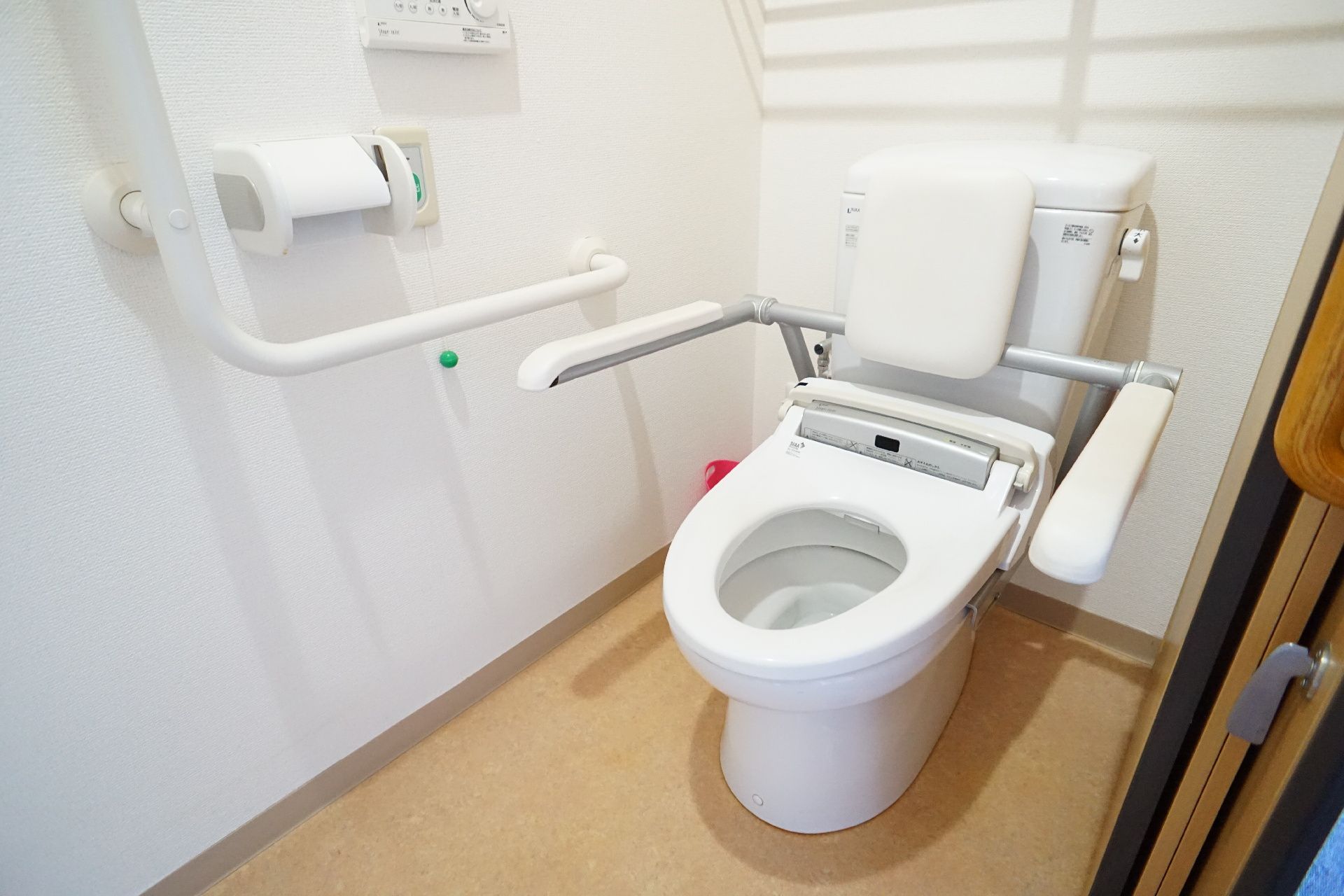 手すりに囲まれた蓋のない洋式便器