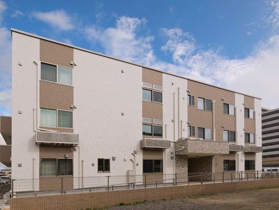 ２種類のベージュ系で構成された、3階建て施設の外観