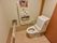 トイレの周りには可動式の手すりと壁に固定された手すりが取り付けられている。トイレットペーパーホルダーは2つ備え付けられている。