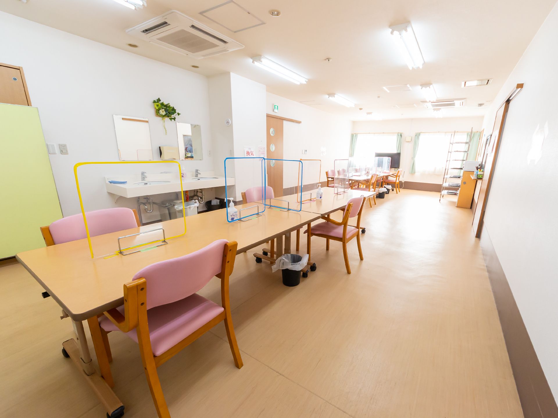 照明が多く取り付けられ、窓からは日差しが差し込んでいる共有スペース