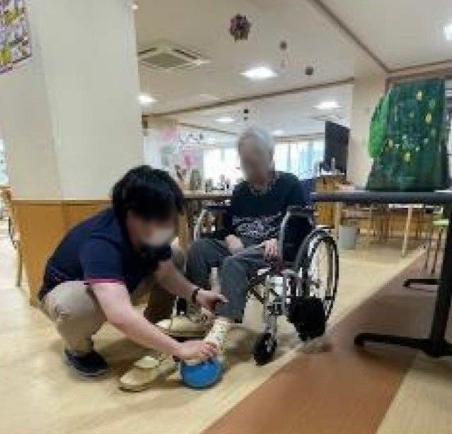高齢女性の肩に手を置き寄り添う女性ヘルパー