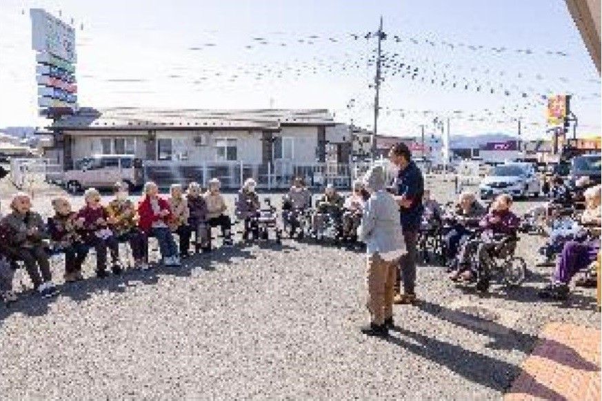 髪を整える高齢女性と後ろで介助をする女性ヘルパー