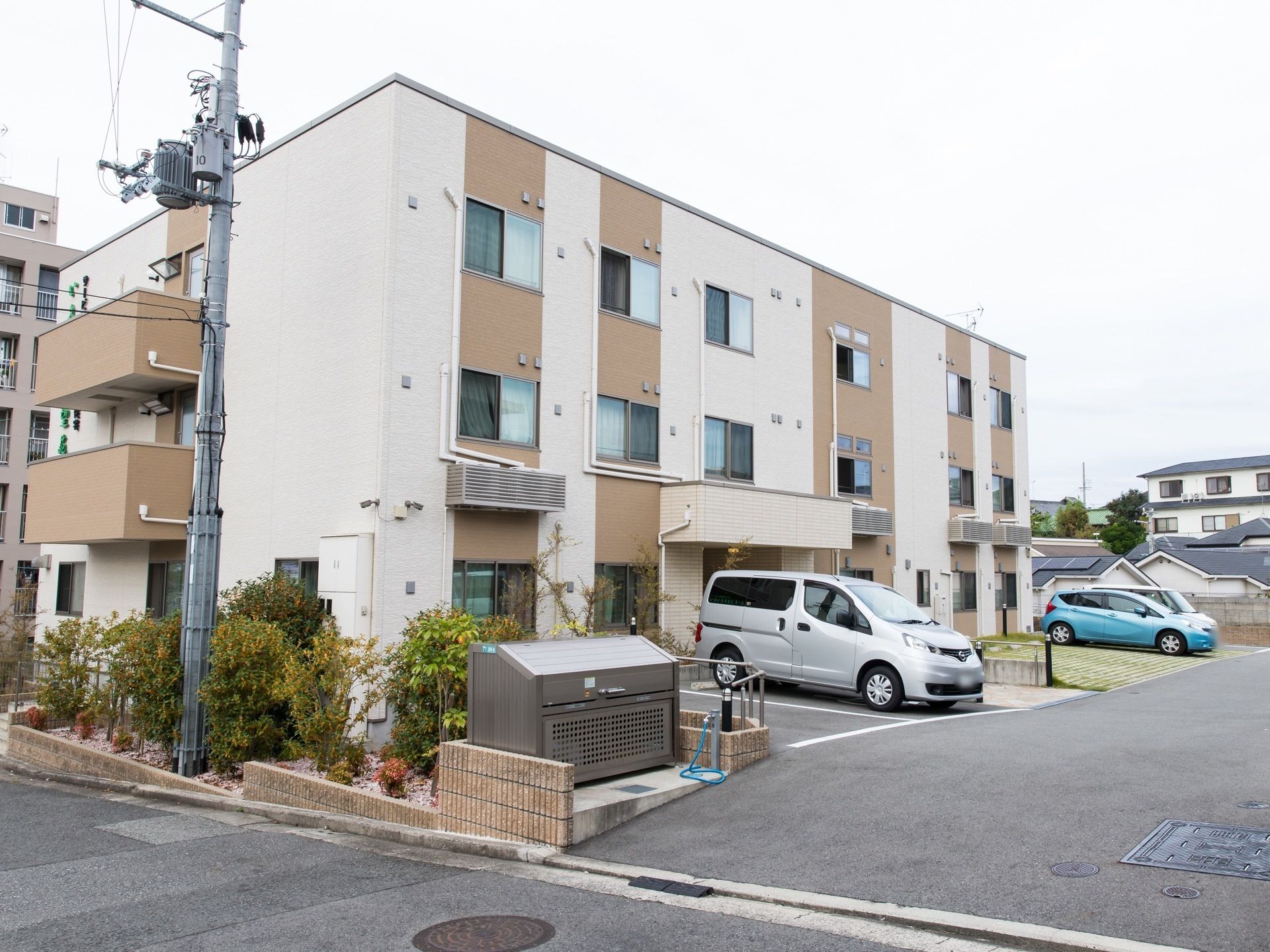 施設は外壁がベージュ色が基調となっており、落ち着いた雰囲気である。建物の前は広い駐車場が設置されている。