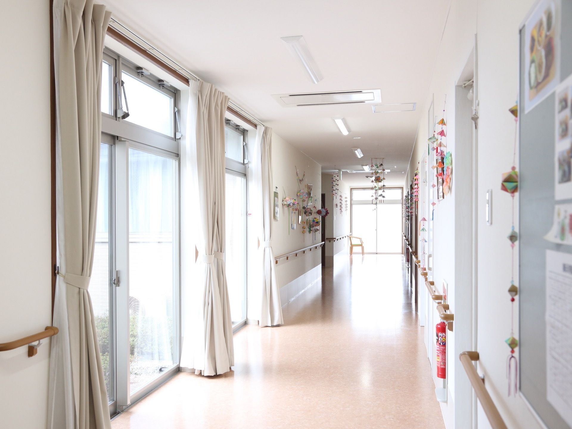 廊下には、大きな窓と小窓が２段に完備されている。手すりや消火器が設置され、安全対策がとられた廊下である。