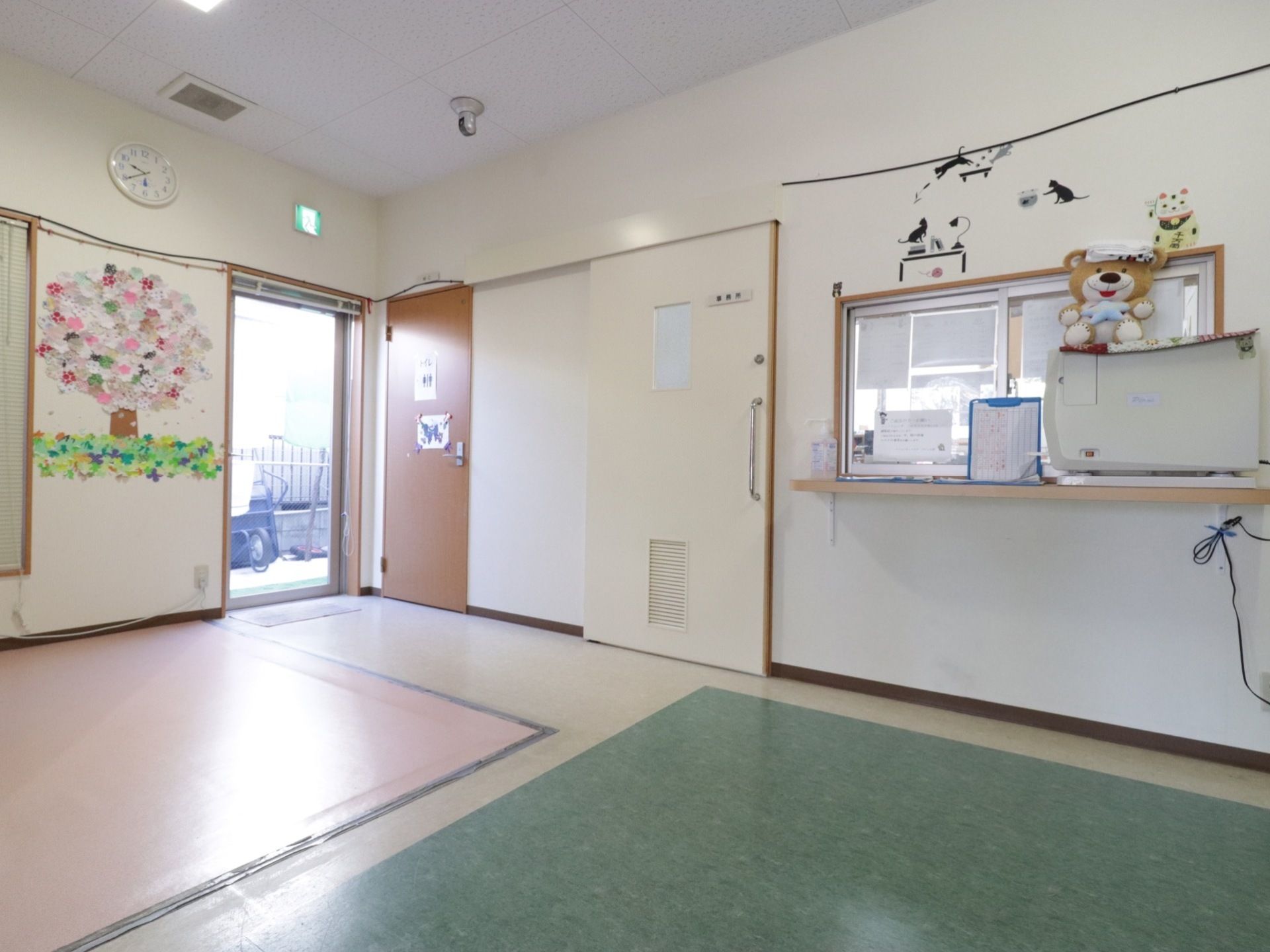受付はかわいい置き物が置かれている。設置されたカウンター上にはホワイトボードや来訪者名簿が設置されている。
