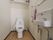 トイレ内には、温水洗浄便座の他に壁付けの洗面台と鏡がある。収納スペースは壁と壁の間に板を挟んで作られており、機能的だ。
