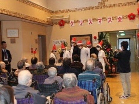 集まった入居者様の前でスタッフによる季節イベントが行われている共有スペース