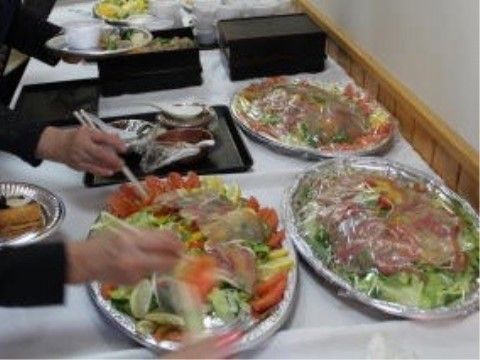 バイキングスタイルで料理を皿に取り分けている入居者様たち