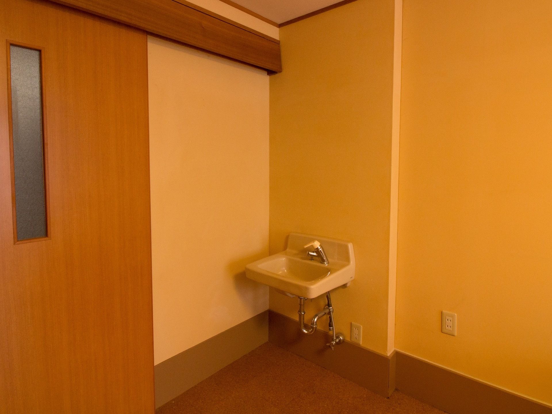 扉は引き戸タイプを採用しており、長方形の明かり窓も設置している。出入口付近には、コンパクトな手洗い場を設けている。