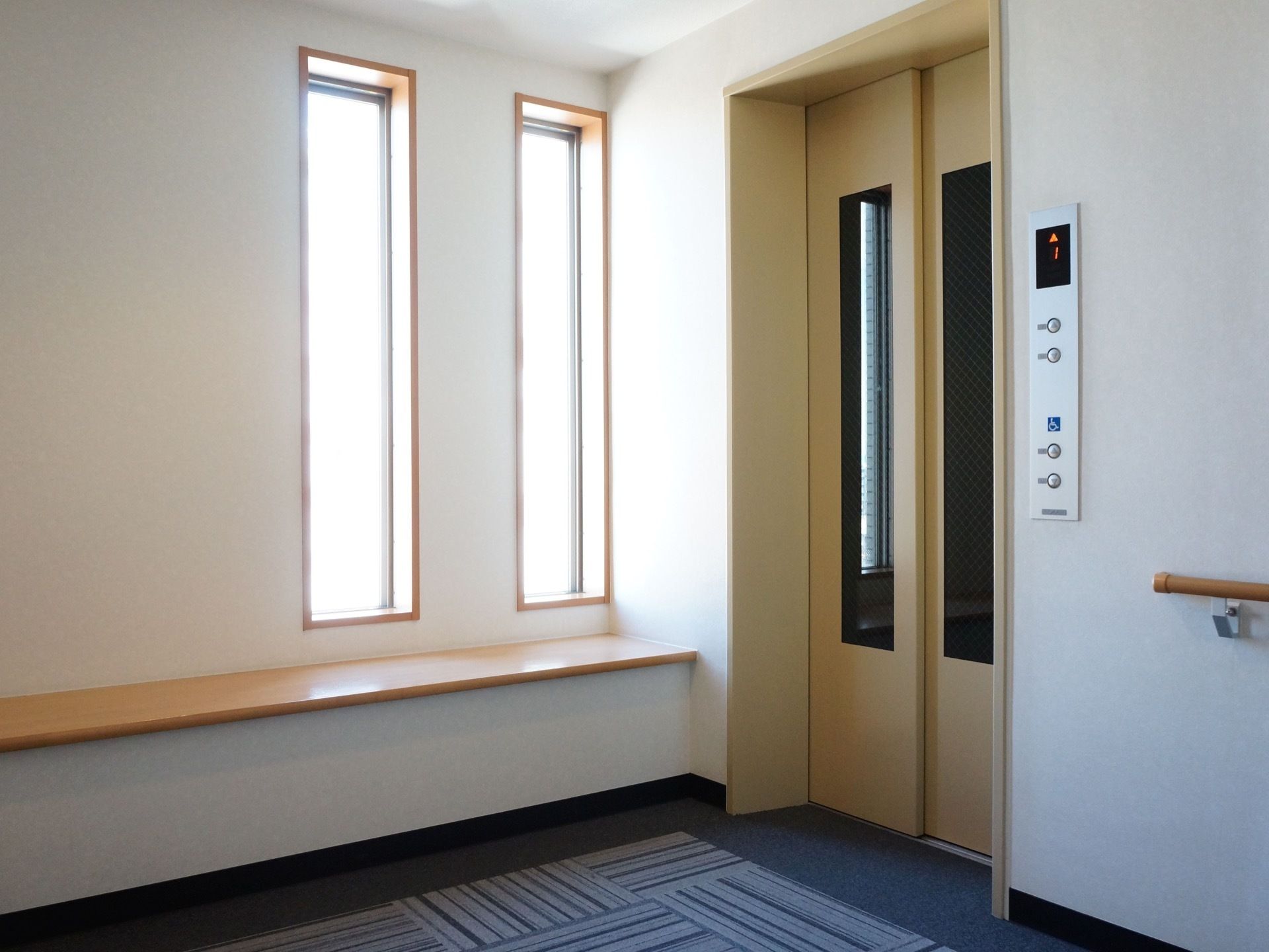 施設内には、バリアフリーのエレベーターを完備している。フロアの壁には手すりがあり、ベンチを備え付けている。