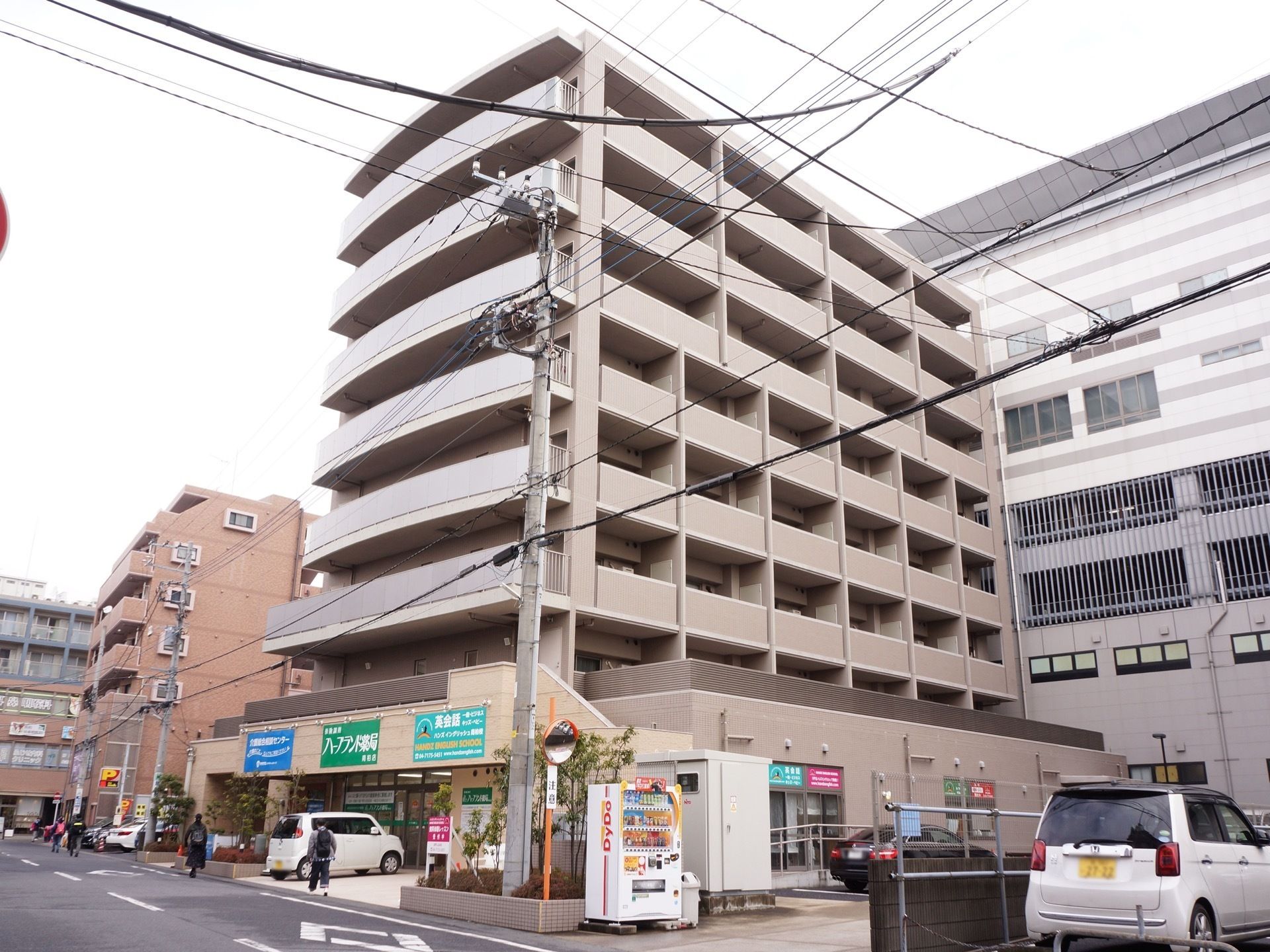 施設は８階建ての建物で、上階にはベランダが用意されている。また１階部分には薬局などが入っていて、自販機が置かれている。