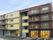 ４階建ての施設はビルのような外観で、両端の棟がチョコレート色、中央がアイボリーの外壁になっている。建物の前には、白線で区切った駐車場がある。