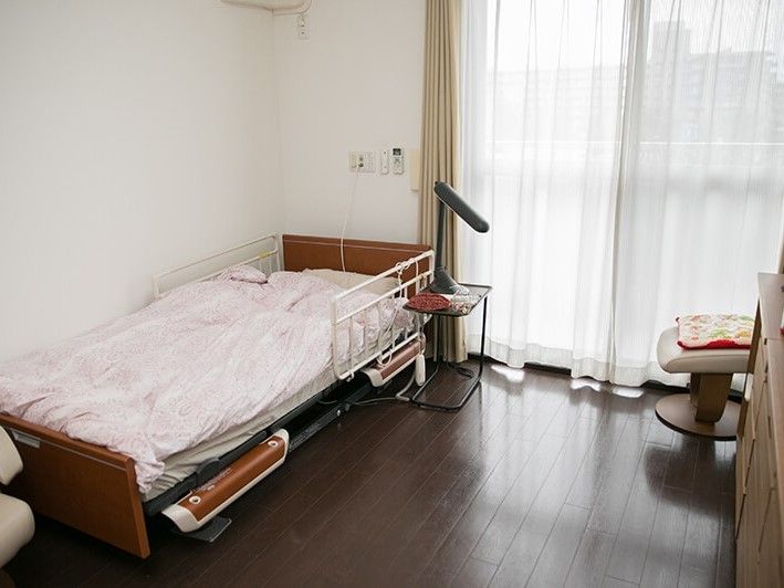 居室には備え付けの介護用ベッドや机が置いてある。陽射しが良く入ってきて、部屋全体が明るい雰囲気である。