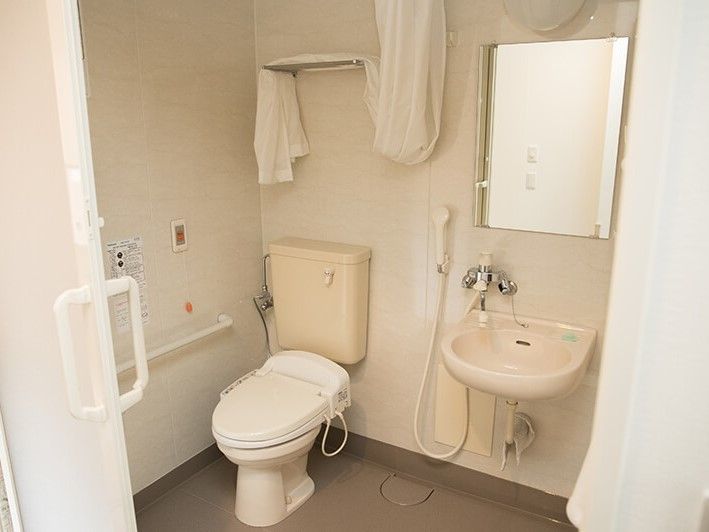 トイレと洗面のスペースには、便利なシャワーもついている。何かあった時の緊急呼び出しボタンも設置されており、安心して利用できる。