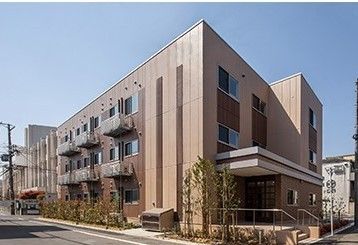 住宅街の一角にある施設。入口付近に手すりが取り付けられた階段とスロープがある。オープンしたばかりの建物はまだ真新しい。