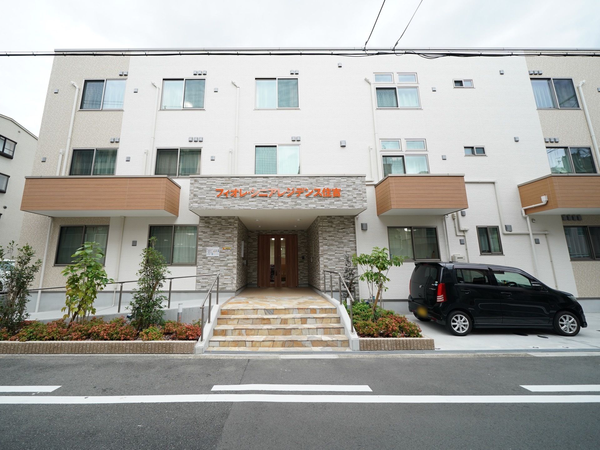 施設は中央の玄関に４段の階段がある、3階建の建物である。片側にはスロープが設けられている。階段を挟んで反対側に駐車スペースがある。